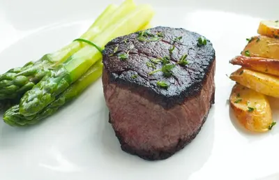 a piece of steak and asparagus on a white plate at Tower 23 Hotel in San Diego