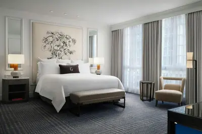 a bedroom with a large white bed and a chair at The US Grant, a Luxury Collection Hotel, San Diego in San Diego