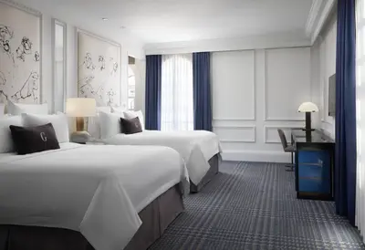 a hotel room with two beds and a desk at The US Grant, a Luxury Collection Hotel, San Diego in San Diego