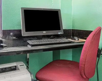 a desk with a computer monitor and a red chair at Quality Inn Hemet - San Jacinto in Hemet