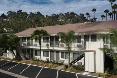 an exterior view of a building with a parking lot at Hotel Iris - Mission Valley-San Diego Zoo-SeaWorld in San Diego