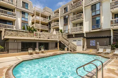 a swimming pool in front of a apartment building at Penthouse Condo w/ Panoramic Ocean Views at Beach Resort in Oceanside