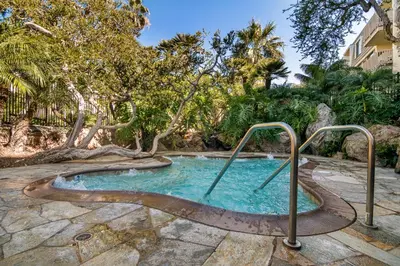 a hot tub in a yard with trees at Penthouse Condo w/ Panoramic Ocean Views at Beach Resort in Oceanside