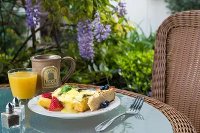 a plate of food on a table with a cup of orange juice at 1906 Lodge in San Diego
