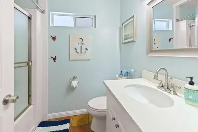 a bathroom with a sink and a toilet and a mirror at Luna Azul, cozy condo only steps to Mission Beach! Free Internet in San Diego