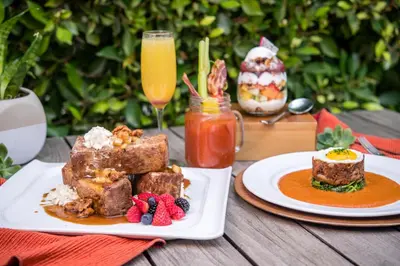 a table with two plates of food and drinks at Estancia La Jolla Hotel & Spa in San Diego