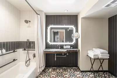 a bathroom with a sink and a tub and a mirror at Estancia La Jolla Hotel & Spa in San Diego