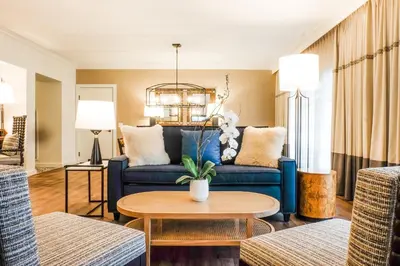 a living room with a blue couch and a table at Estancia La Jolla Hotel & Spa in San Diego