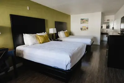 a hotel room with two beds with yellow pillows at Old Town Western Inn in San Diego