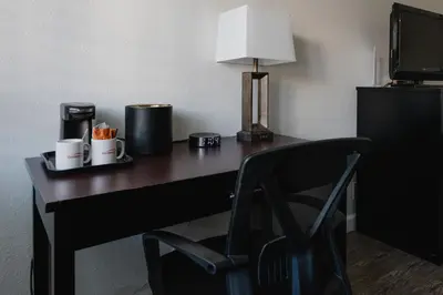 a desk with a lamp and a chair in a room at Old Town Western Inn in San Diego