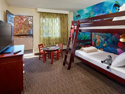a bedroom with a bunk bed with a desk and a table at Mission View Inn & Suites San Diego Sea World - Zoo in San Diego