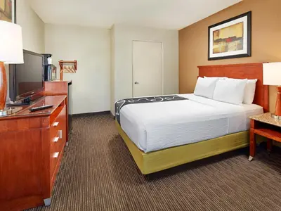 a hotel room with a bed and a flat screen tv at Mission View Inn & Suites San Diego Sea World - Zoo in San Diego
