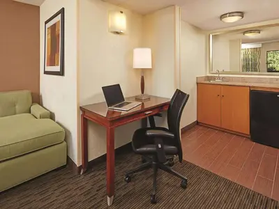 a room with a desk with a laptop and a chair at Mission View Inn & Suites San Diego Sea World - Zoo in San Diego