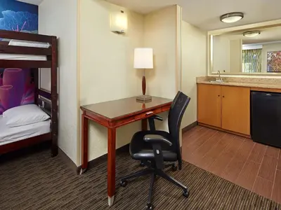 a room with a desk and a bed and a bunk bed at Mission View Inn & Suites San Diego Sea World - Zoo in San Diego