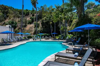 a swimming pool with chairs and umbrellas at Sheraton Mission Valley San Diego Hotel in San Diego