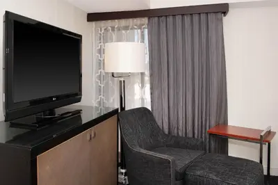a living room with a tv and a chair and a television at Sheraton Mission Valley San Diego Hotel in San Diego