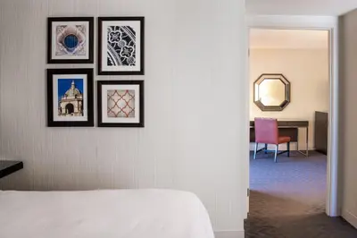 a bedroom with four framed pictures on a wall at Sheraton Mission Valley San Diego Hotel in San Diego