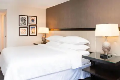 a bedroom with a large bed with white sheets and pillows at Sheraton Mission Valley San Diego Hotel in San Diego