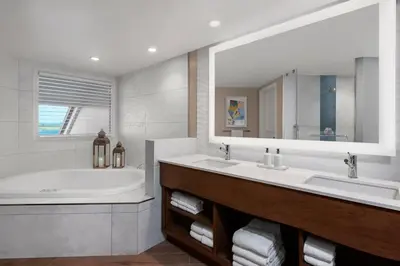 a bathroom with two sinks and a tub and a mirror at San Diego Mission Bay Resort in San Diego