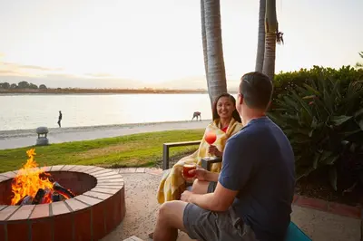 a man and a woman sitting next to a fire pit at San Diego Mission Bay Resort in San Diego