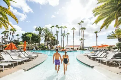 two people walking into a swimming pool at a resort at San Diego Mission Bay Resort in San Diego
