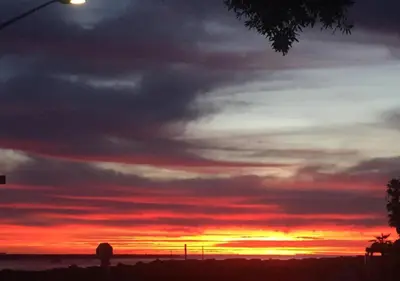 a sunset with the sun setting in the sky at MB Jamaica FLAT - Steps 2 Mission Beach in San Diego