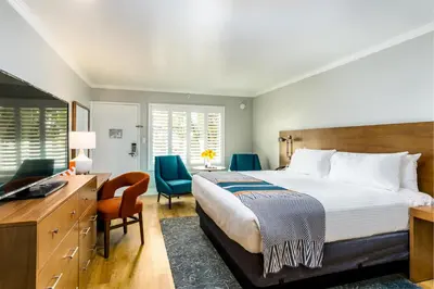 a bedroom with a bed and a desk and a television at Town and Country San Diego in San Diego