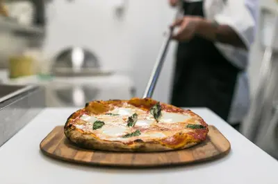 a pizza on a cutting board on a counter at Town and Country San Diego in San Diego