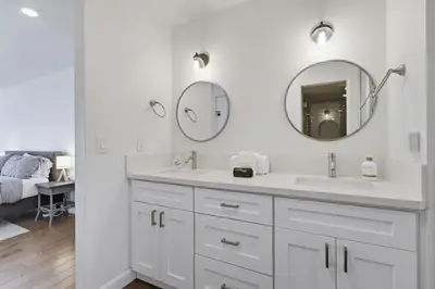 a white bathroom with a sink and two mirrors at Beachfront feat Private Den SS166 in Solana Beach