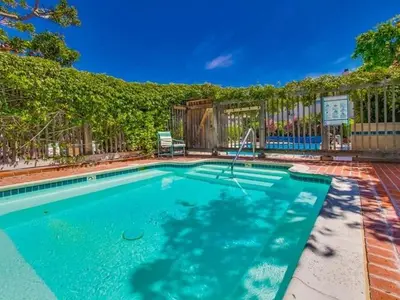 a large swimming pool with a fence at Beachfront feat Private Den SS166 in Solana Beach