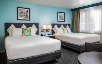 two beds in a hotel room with blue walls at Kings Inn in San Diego