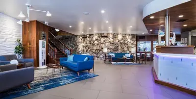 a lobby with blue chairs and a stone wall at Kings Inn in San Diego