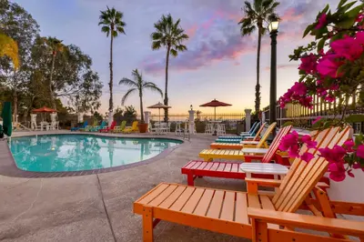 a pool with lounge chairs and palm trees in a resort at Best Western Plus Hacienda Hotel Old Town in San Diego
