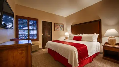 a bedroom with a large bed with a red blanket at Best Western Plus Hacienda Hotel Old Town in San Diego