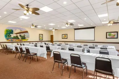 a conference room with white tables and chairs and a screen at Best Western Plus Hacienda Hotel Old Town in San Diego