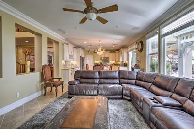a living room with a leather couch and a ceiling fan at Luxe San Diego Getaway with Pool and Ocean Views in San Diego