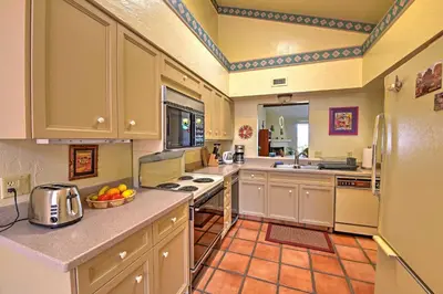 a large kitchen with white cabinets and a sink at Borrego Springs Condo with Private Patio and Views! in Borrego Springs