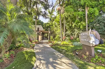 a garden path with a sign that says out cut out village at Beachfront Oceanside Condo with Pool and Hot Tub! in Oceanside