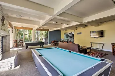 a large living room with a pool table at Beachfront Oceanside Condo with Pool and Hot Tub! in Oceanside