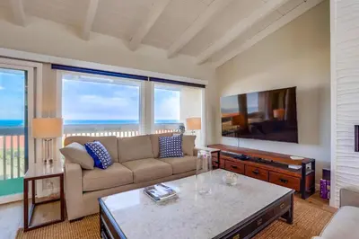 a living room with a couch and a flat screen tv at Beach Access Oceanview SBTC331 Condo in Solana Beach