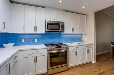 a kitchen with white cabinets and a stove and microwave at Beach Access Oceanview SBTC331 Condo in Solana Beach