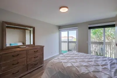 a bedroom with a bed and a dresser with a mirror at Beach Access Oceanview SBTC331 Condo in Solana Beach
