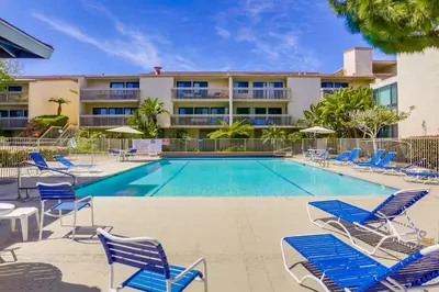 a swimming pool with lounge chairs and a hotel at Beach Access Oceanview SBTC331 Condo in Solana Beach