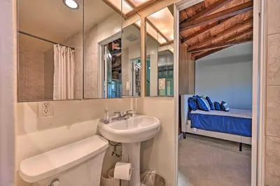a bathroom with a sink and a toilet and a bed at La Jolla Home and Detached Suite Hot Tub and Backyard in San Diego