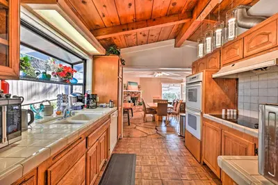 a kitchen with wooden cabinets and a large window at La Jolla Home and Detached Suite Hot Tub and Backyard in San Diego