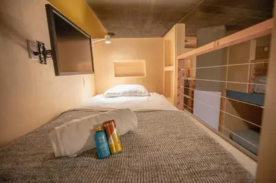 a small bedroom with a bed with a tv on it at PodShare San Diego in San Diego