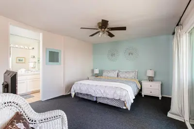 a bedroom with a bed and a ceiling fan at 3 Bedroom! - Complex is on the beach with huge pool in Oceanside