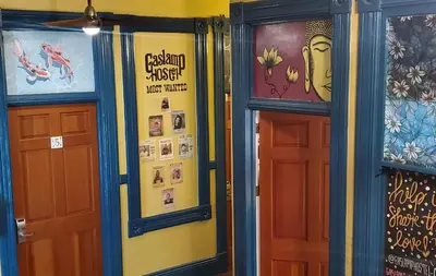 two doors in a room with paintings on the walls at Gaslamp Hostel in San Diego
