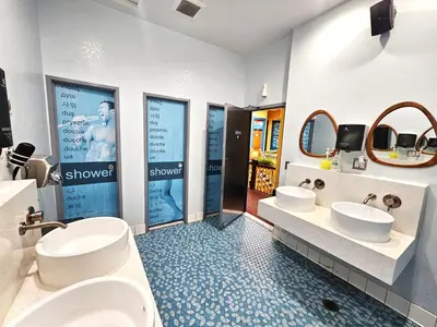 a bathroom with two sinks and two mirrors at Gaslamp Hostel in San Diego