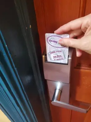 a person is putting a pack of money in a refrigerator at Gaslamp Hostel in San Diego